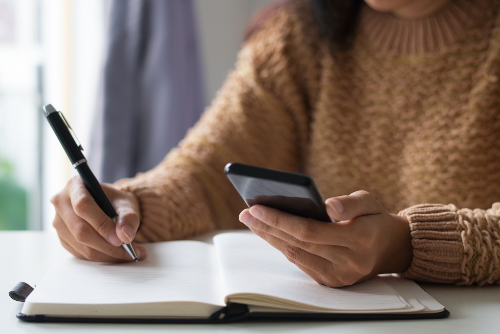 close-up-businesswoman-planning-timetable-using-smartphone.jpg тетрадь