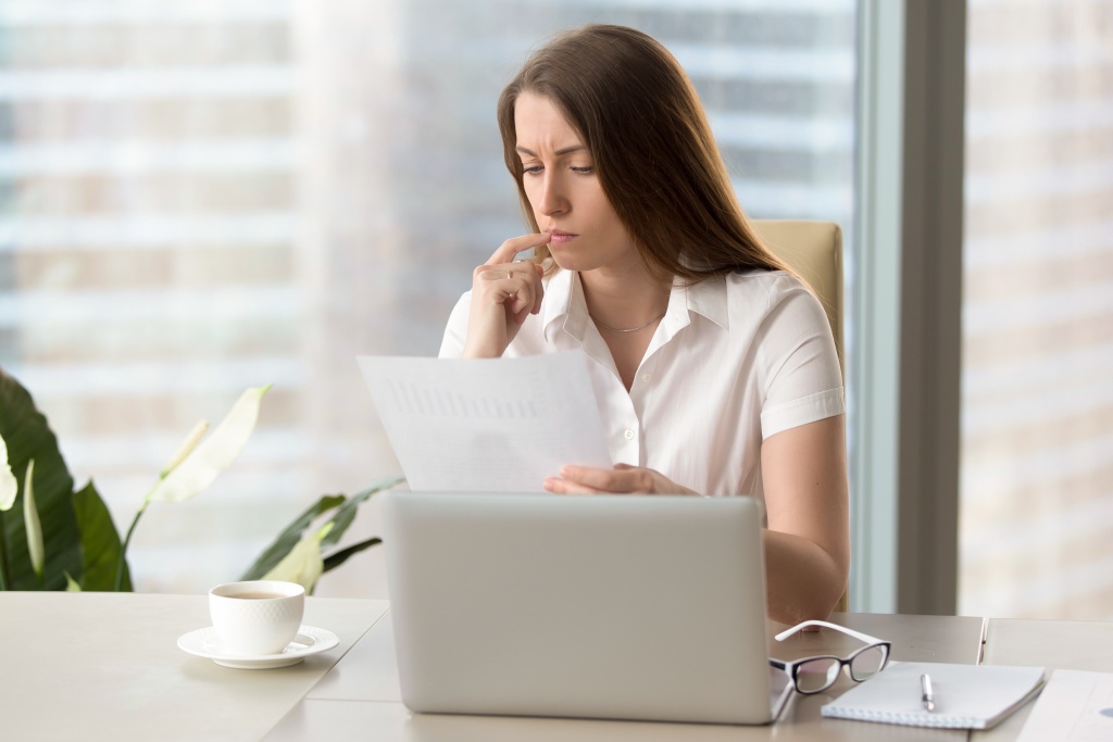 focused-businesswoman-analyzing-document-holding-financial-report-workplace.jpg окно